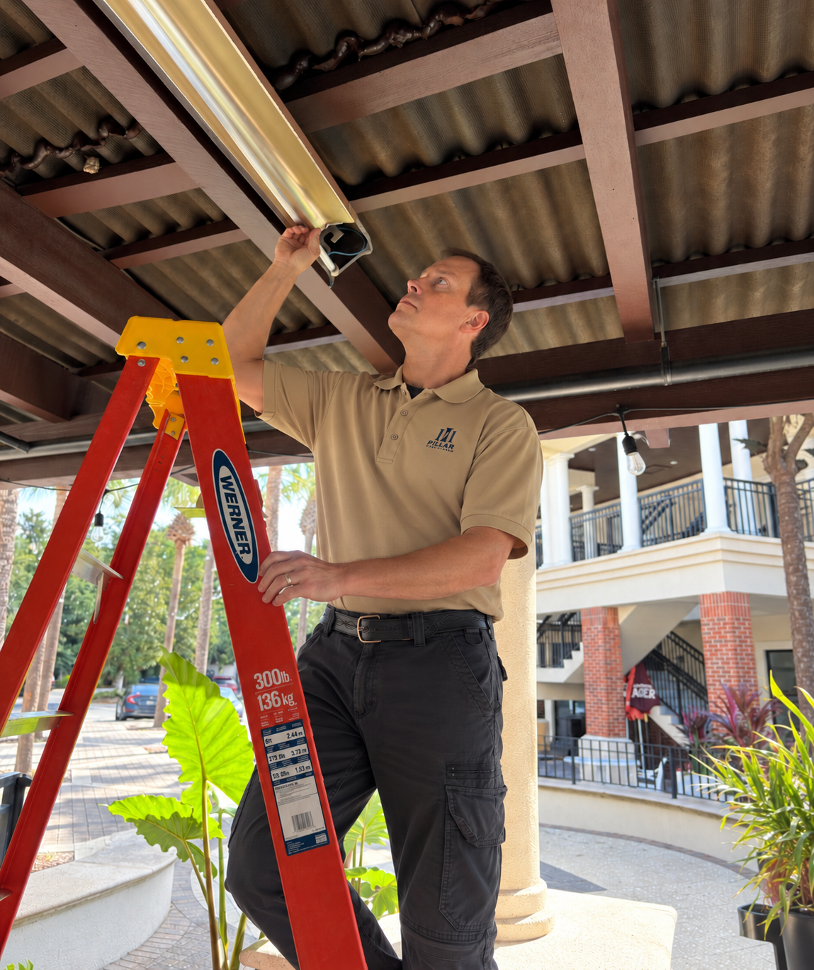 Illustrative image of electrician inspecting an overhead light fixture